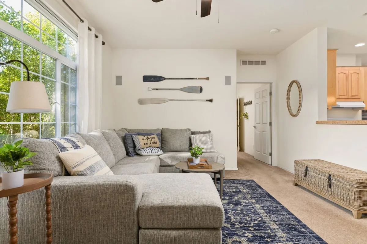 A welcoming interior scene featuring a comfortable sofa, stylish paddles as wall decor, a cozy rug, and a lamp. The space feels both playful and homey, suitable for lounging or playtime with pets and family.